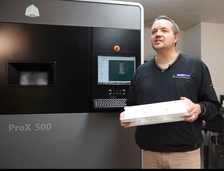 Alan Bradshaw, CEO of Idaho Steel, holds a piston produced six times faster by the ProX 500 SLS printer